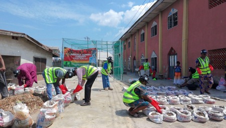 Community members sort compost into bags.